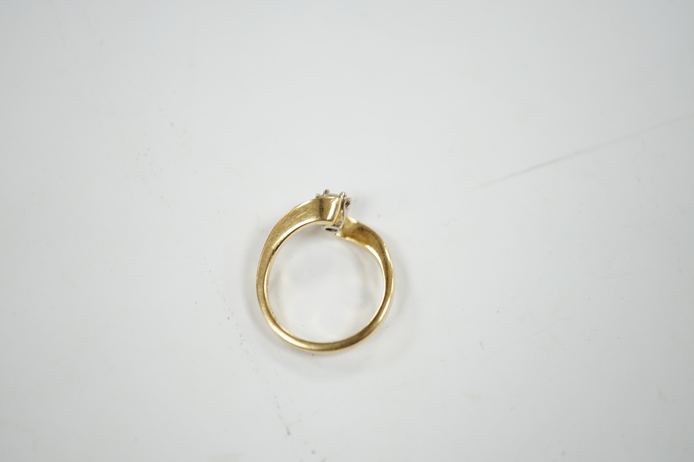 A modern 18ct gold and solitaire diamond set ring, with crossover shoulders, size K, gross weight 4 grams.